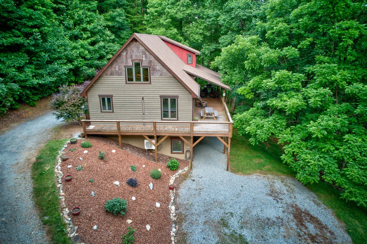 A view of the wooden deck overlooking a landscaped garden, emphasizing outdoor living with plenty of space for relaxation and gatherings. The deck is an inviting space for guests and pets to enjoy the mountain air together.